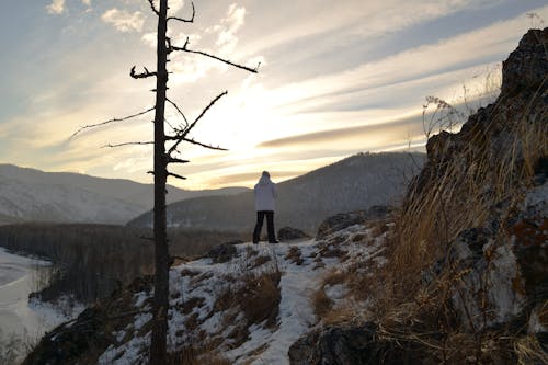 Free Person in White Jacket Standing on the Mountain Stock Photo