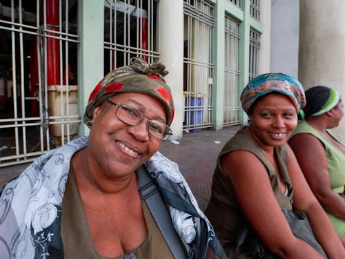 Smiling Women Sitting in Front of a Building Gate