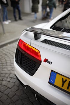Close-up of a white sports car showcasing its rear spoiler and sleek design.