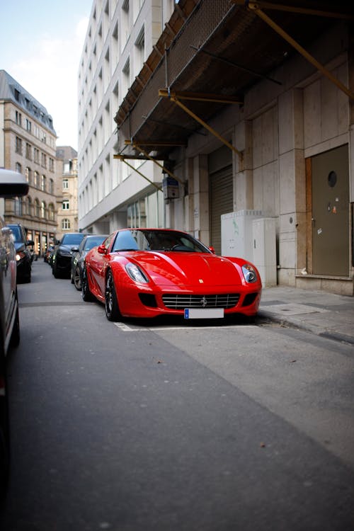 Red Ferrari Sports Car Parked on the Street Near Building