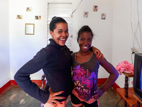 A Woman in Black Sweater and a Girl in Sleeveless Shirt Smiling