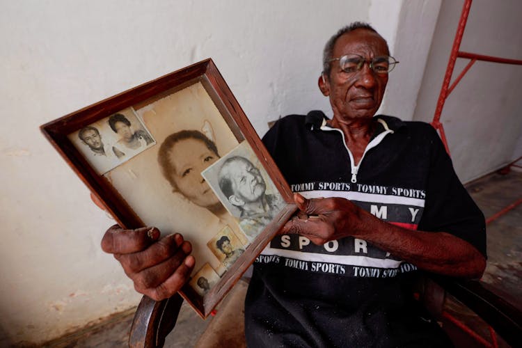 Elderly Man Holding Old Photographs