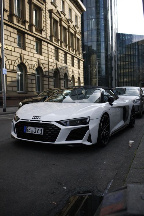 Free White Audi convertible parked on city street with modern and historic architecture. Stock Photo