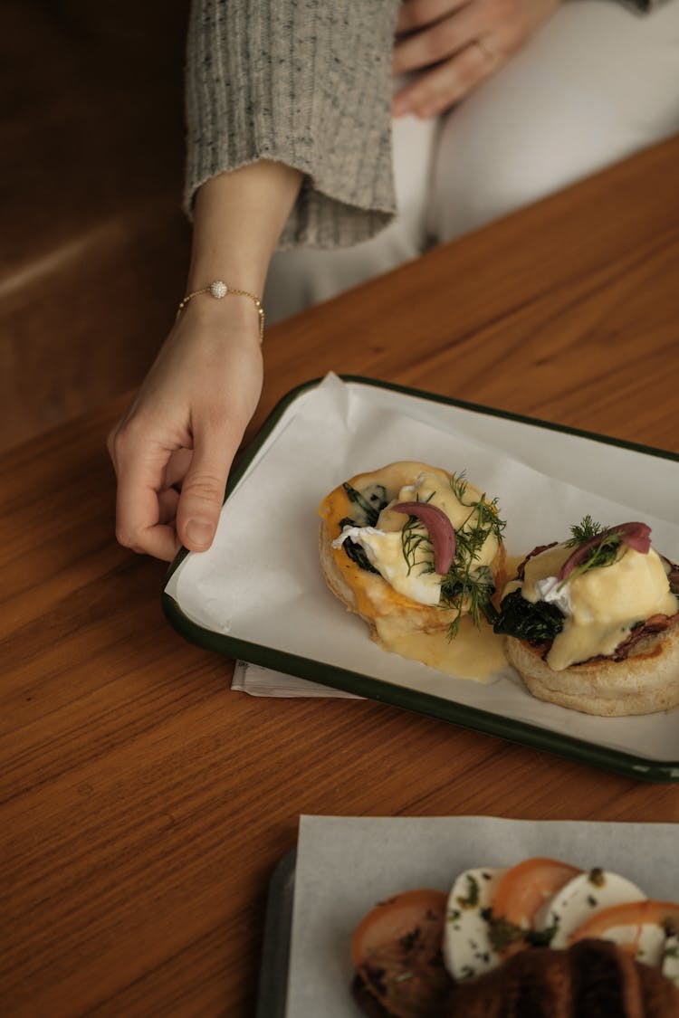 Woman Holding Plate With Breakfast Muffin