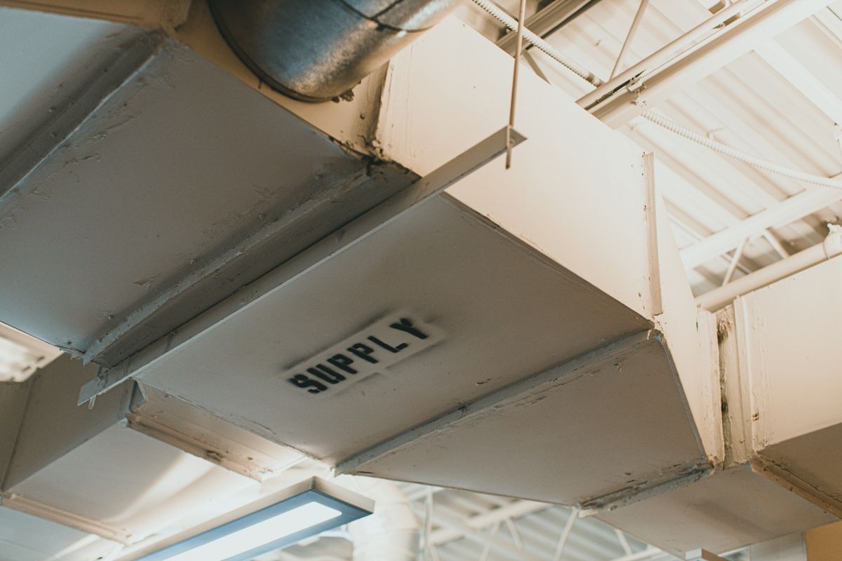 Rectangular supply-air ductwork labeled SUPPLY in an interior ceiling system