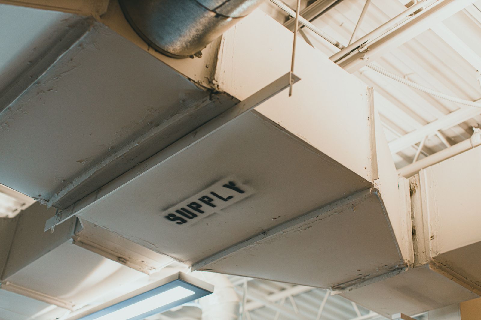 Close-up of an industrial air duct labelled SUPPLY.