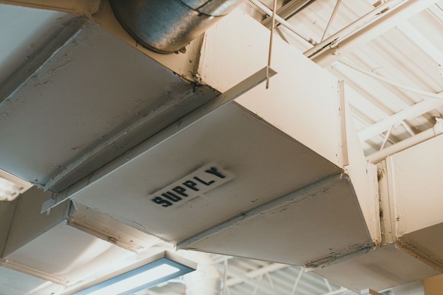 Close-up of a supply air duct labeled SUPPLY in a mechanical space