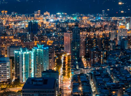 Free Aerial view of a brightly lit cityscape at night showcasing skyscrapers and bustling city lights. Stock Photo
