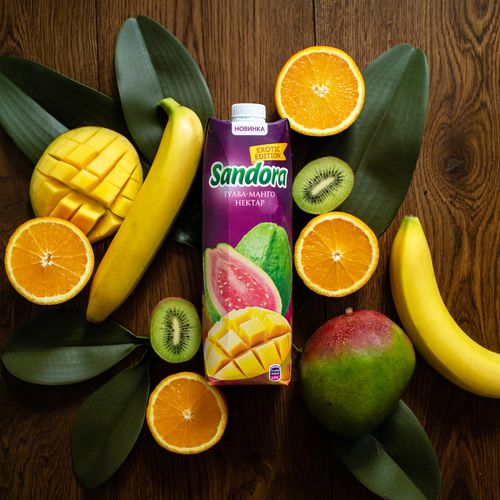 Free Vibrant tropical fruit layout with juice carton on wooden table. Stock Photo