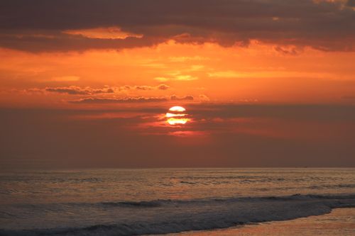 Free Breathtaking sunset over tranquil ocean waves, showcasing vibrant orange hues and serene nature. Stock Photo
