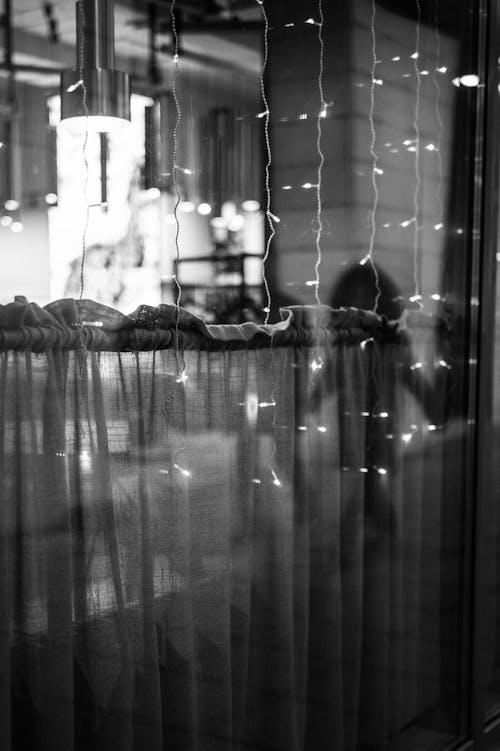 Free A Grayscale of a Curtain by the Window Stock Photo