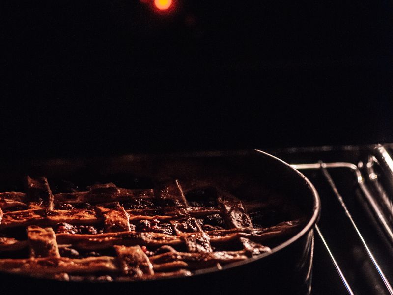 Oven that needs same-day repair Cherry pie with a lattice crust baking in an oven