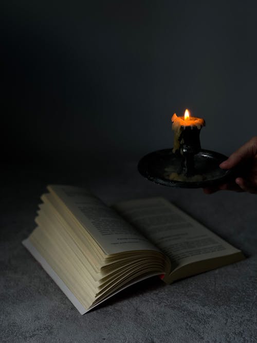 An Open Book and Candle on the Table 