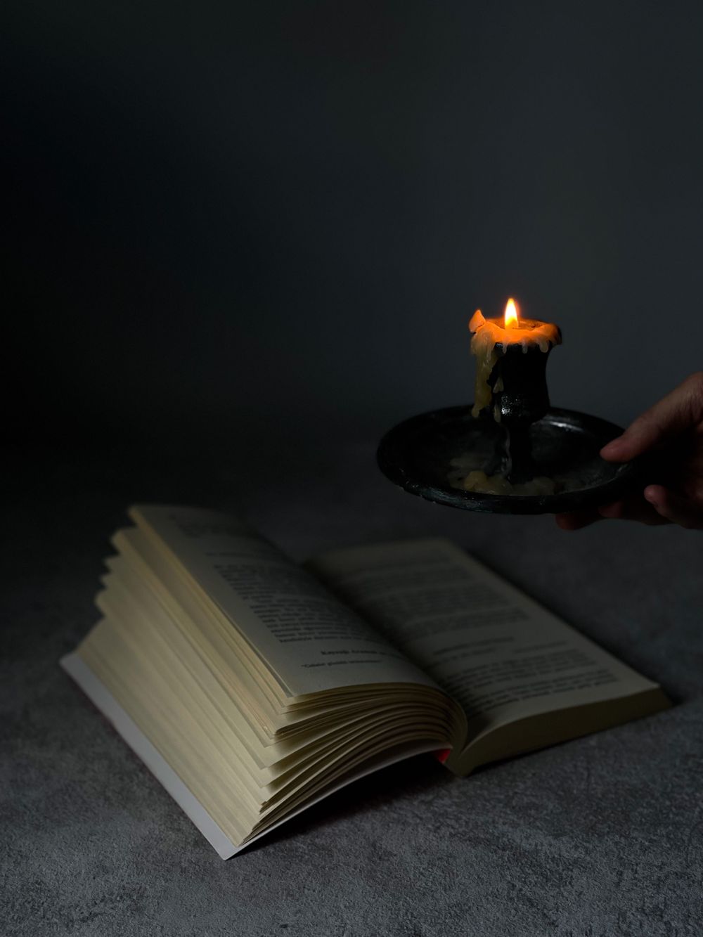 Bíblia aberta iluminada por uma vela, símbolo de fé e devoção