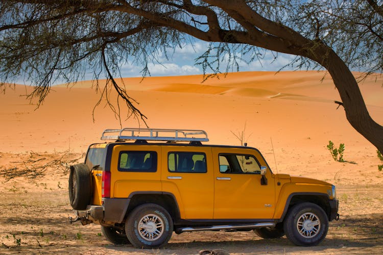 Side View Of A Yellow SUV On The Desert