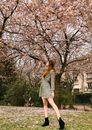 Woman in White and Black Floral Dress Standing Near Brown Tree