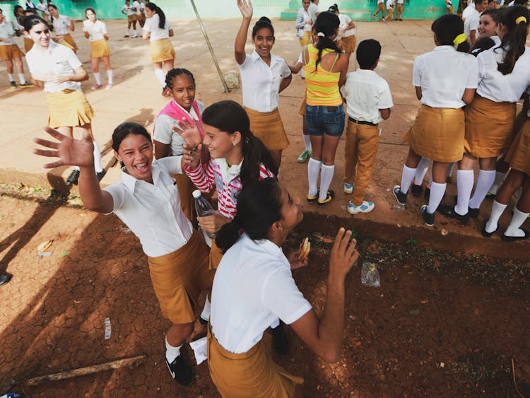 Group Of School Children Waving At Camera