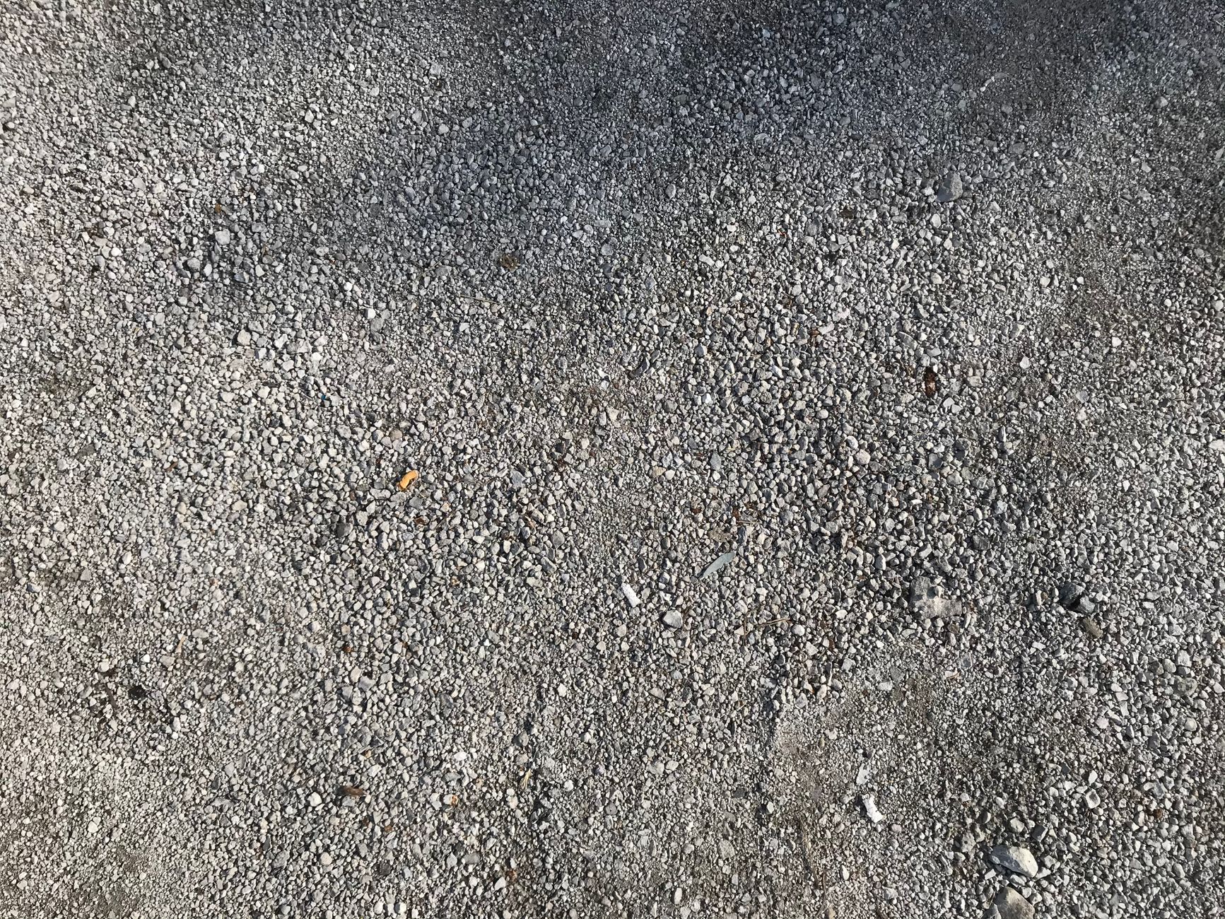 Close-up of gray gravel texture on a concrete floor, perfect for backgrounds.
