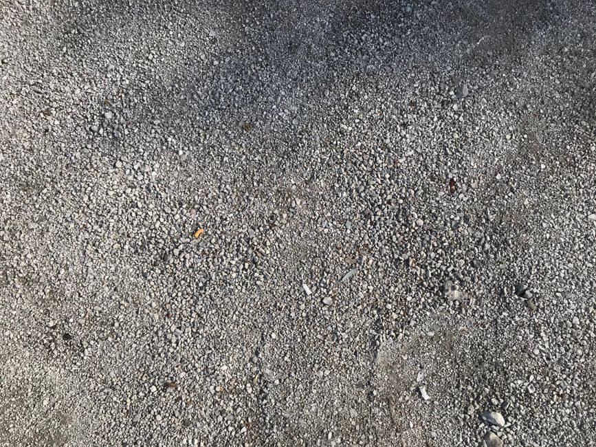 Close-up of gray gravel texture on a concrete floor, perfect for backgrounds.