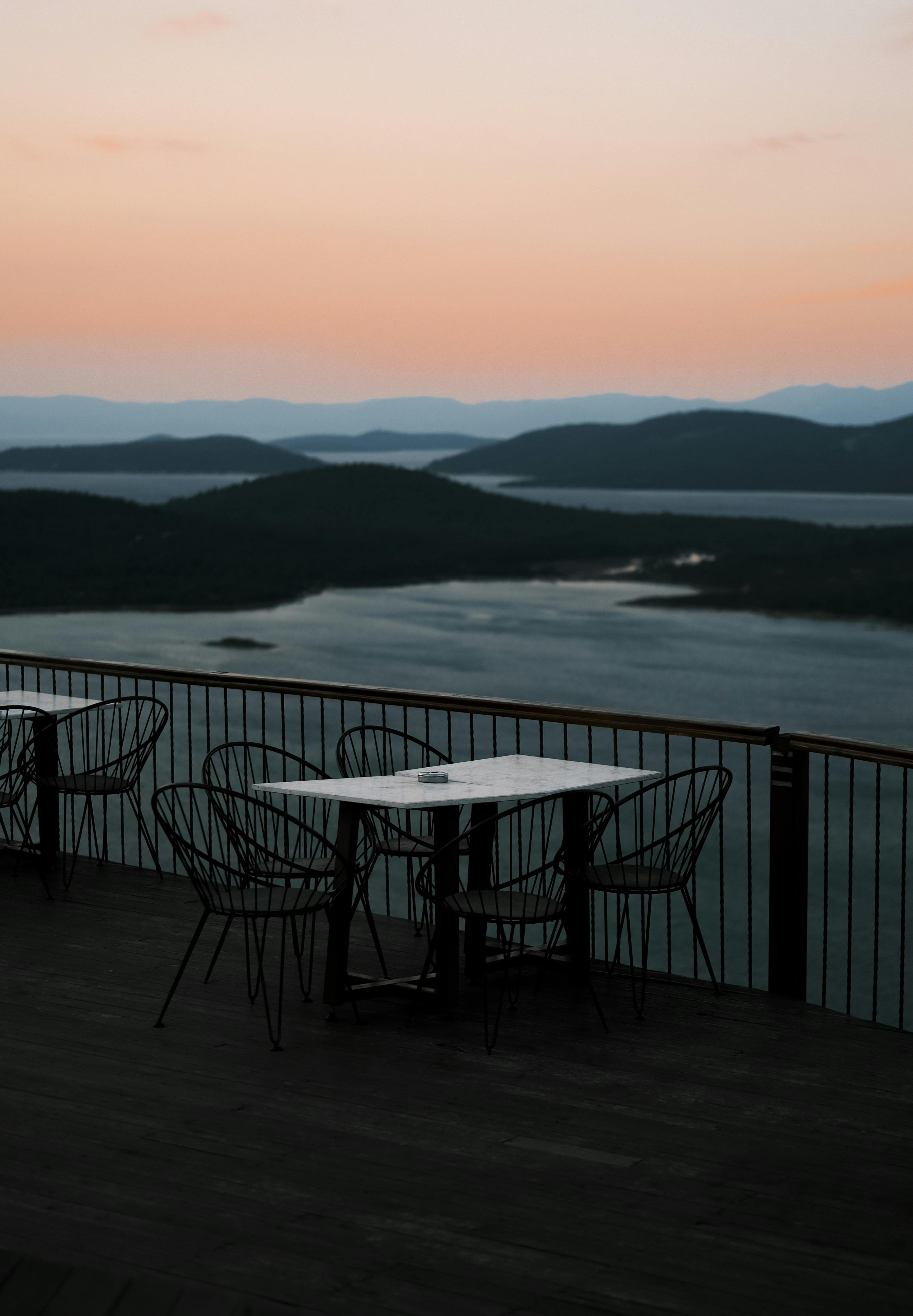 Tranquil sunset view over a mountain lake from a terrace, perfect for serene moments.