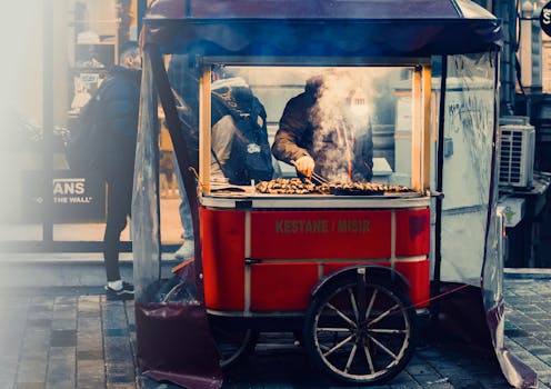 Roasted chestnut vendor in Beyoğlu, Istanbul on a bustling street. Warm atmosphere.