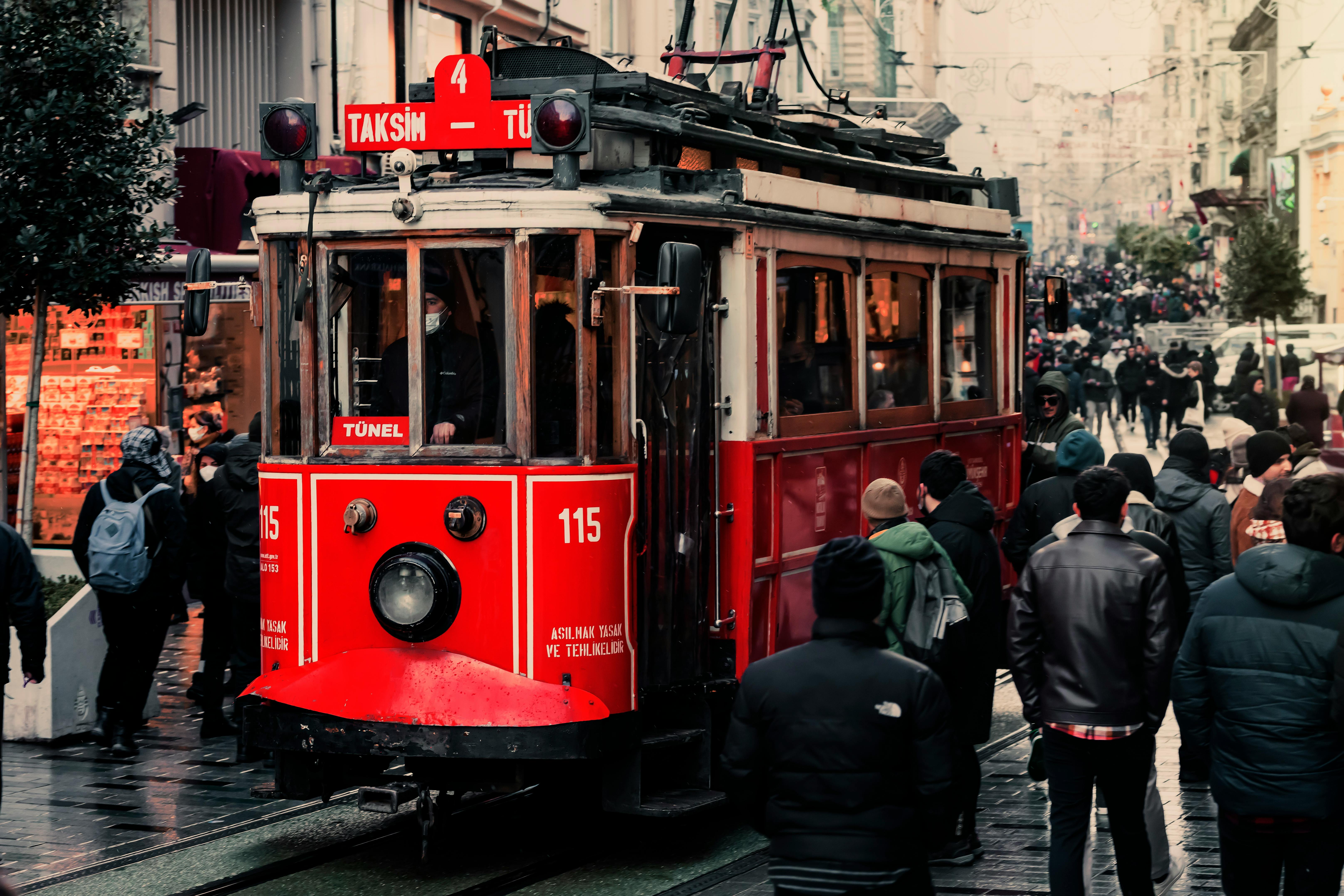 Free Iconic red tram navigating through bustling Beyoğlu, Istanbul, with a vibrant urban atmosphere. Stock Photo
