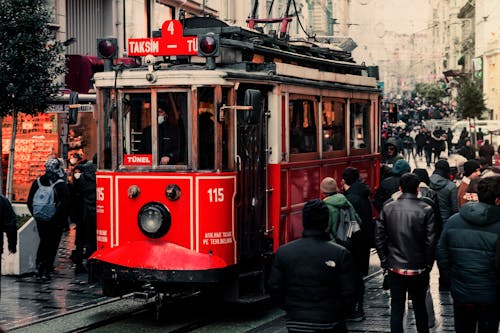 People Walking on the Street Near the Red Tram