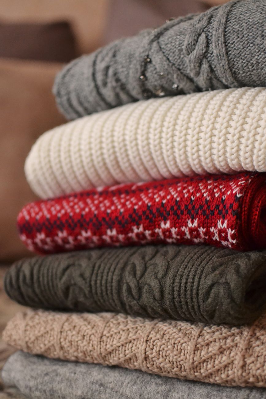 Pull en maille posé à plat sur une serviette blanche propre prêt pour la méthode de séchage en rouleau de serviette