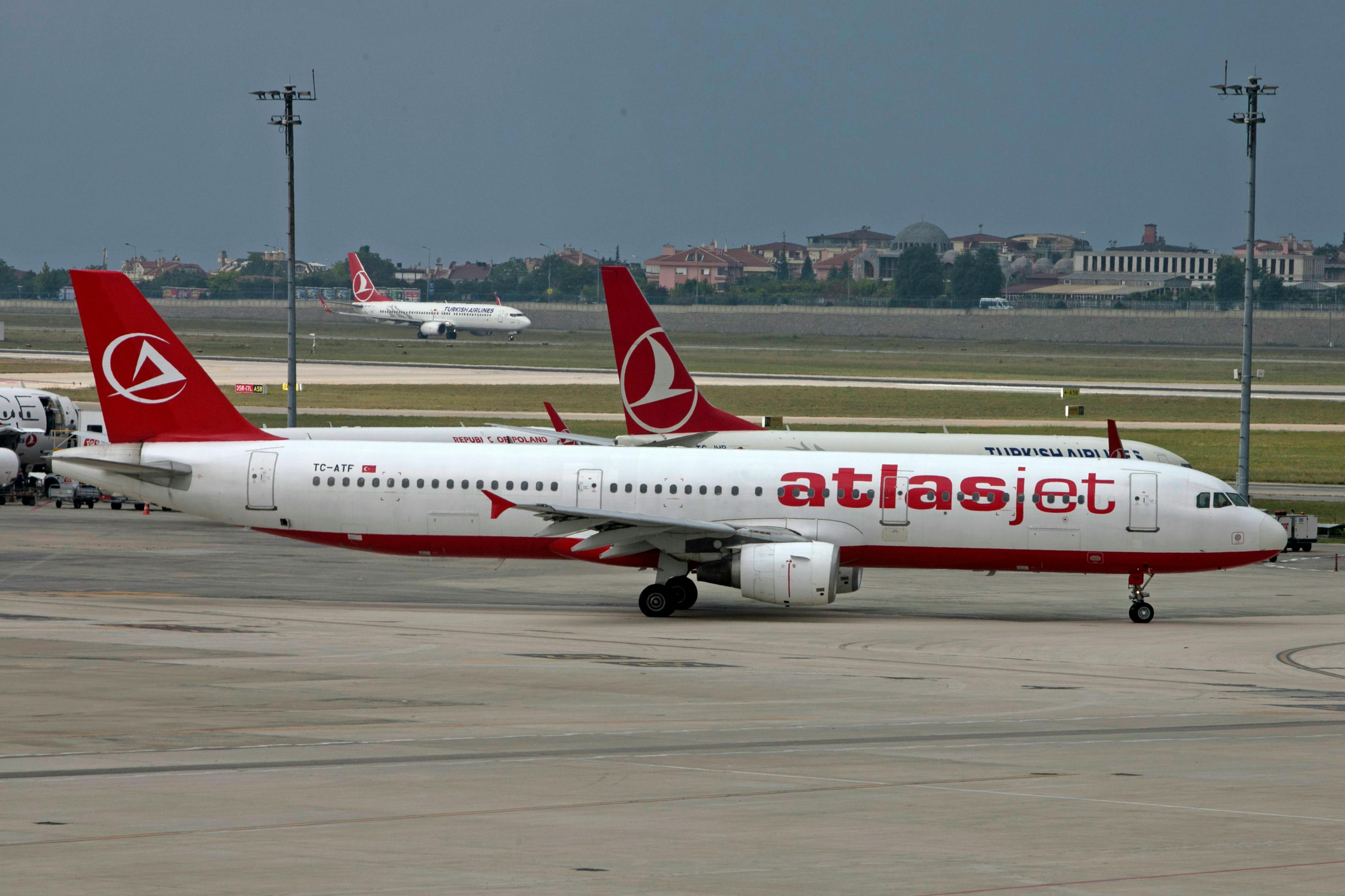 Free An Atlasjet aircraft on a tarmac with a cityscape in the background. Stock Photo