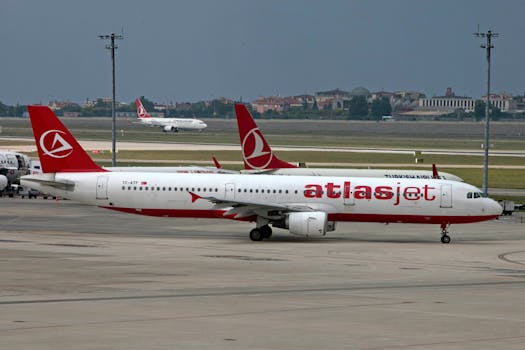 An Atlasjet aircraft on a tarmac with a cityscape in the background.