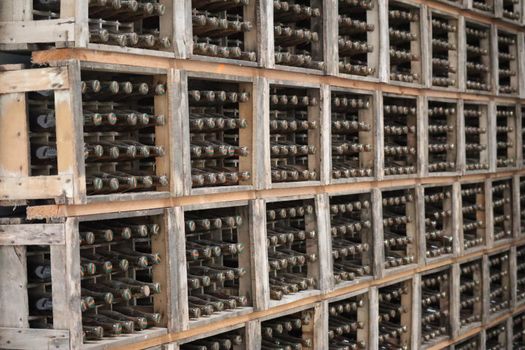 Rustic wooden crates filled with stacked beer bottles in a storage setting, perfect for brewery stock imagery.