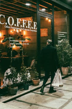 A man walks past a lit coffee shop at night in Kermanshah, Iran.
