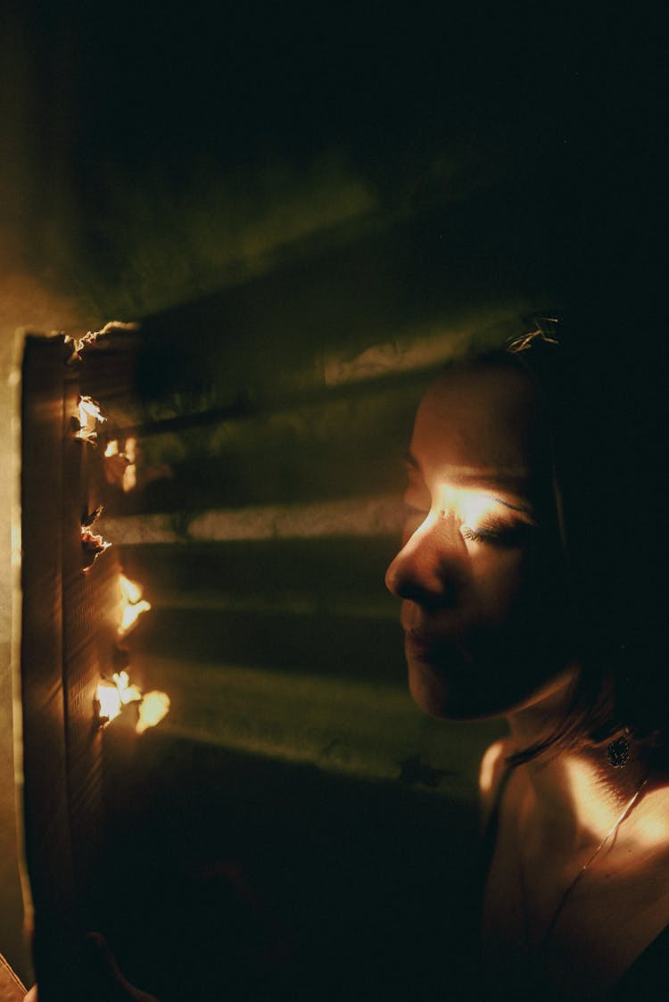 Light Coming In Onto Face Through Holes In Cardboard