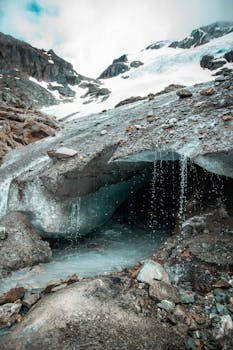 Stunning view of a natural glacier cave with melting snow and water stream in Ushuaia, Argentina.