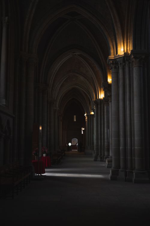Free Dark and atmospheric corridor inside Lausanne Cathedral with Gothic arches. Stock Photo
