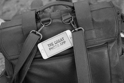 Grayscale Photo of Black Leather Bag With White Tag