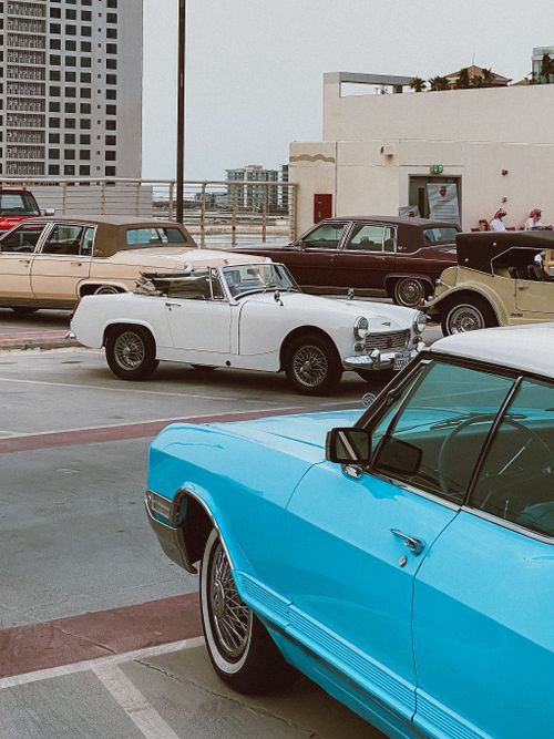 Free A display of classic cars parked in a city rooftop lot, showcasing vintage automobile designs. Stock Photo