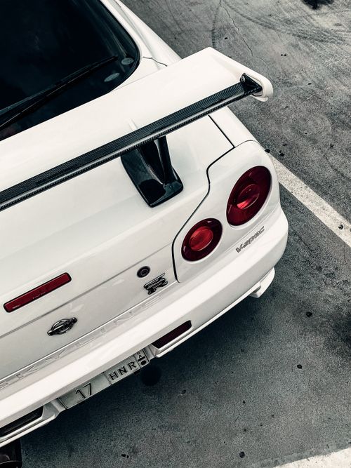 Free Dynamic shot of a white sports car's rear with a visible spoiler, highlighting speed and design. Stock Photo