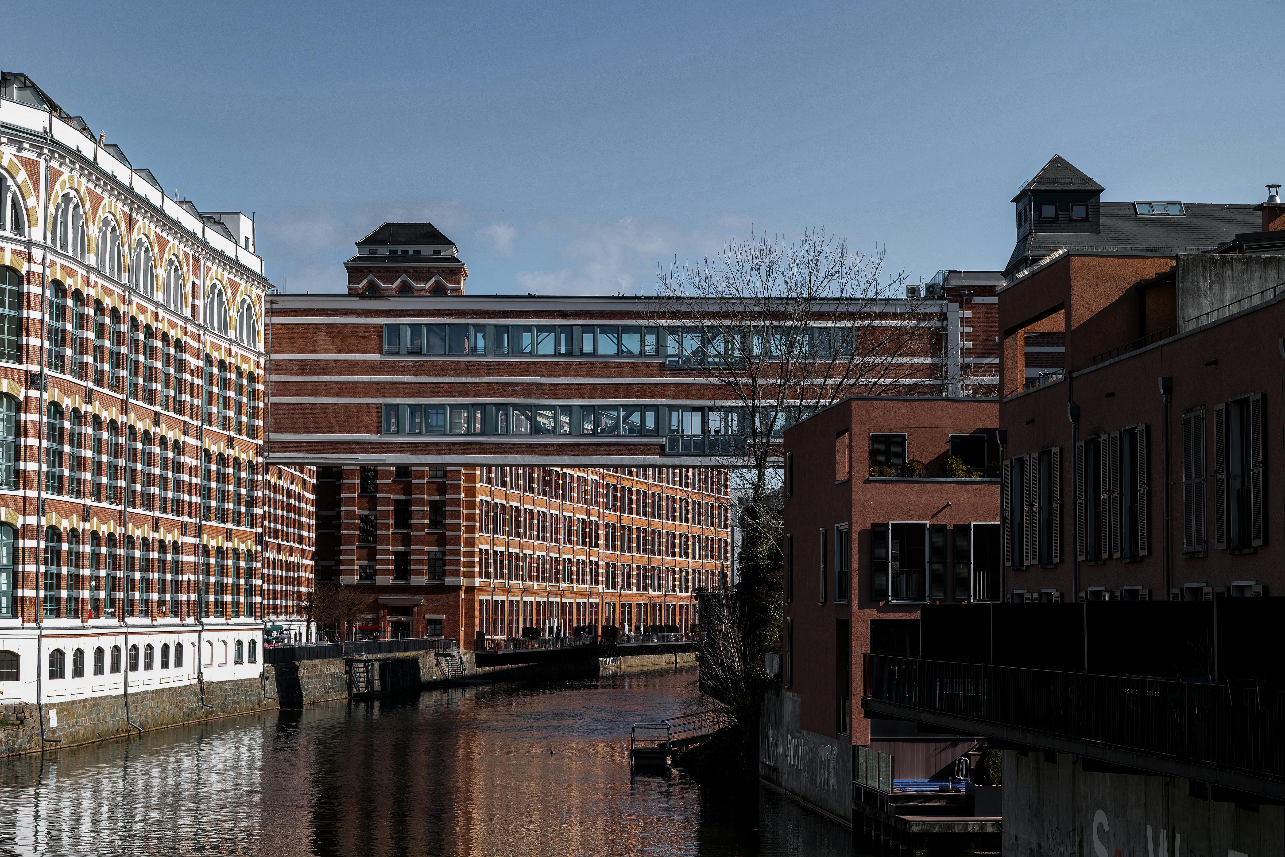 A scenic view of the Karl Heine Canal in Leipzig, showcasing historic architecture and calm waters.