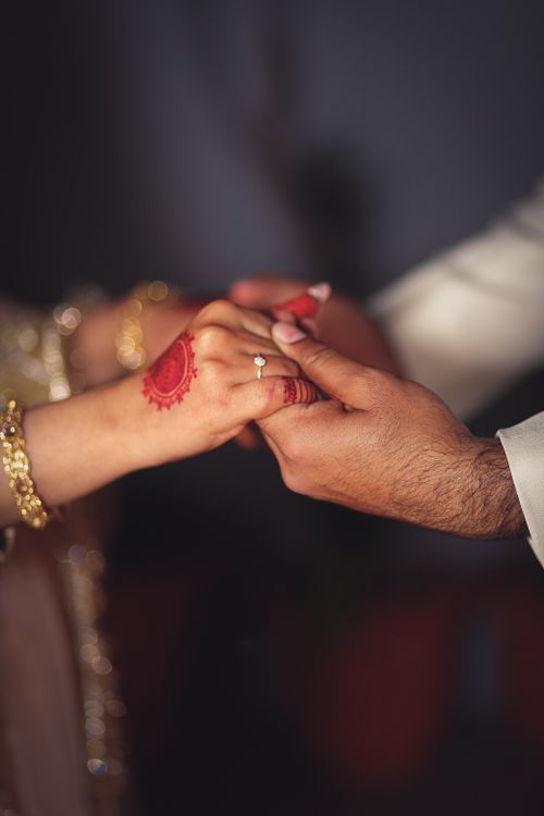 Free Close-up of a couple exchanging vows, showcasing elegant henna design and wedding rings. Stock Photo