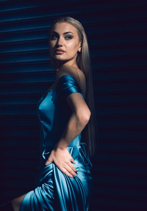 Free Stylish woman posing in blue dress with dramatic lighting in Istanbul, Turkey. Stock Photo