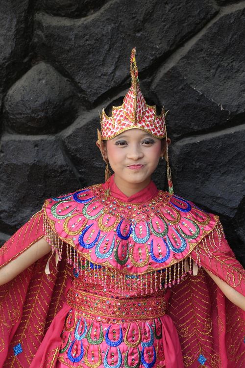 Free Woman in vibrant traditional attire with headwear posing against a dark backdrop. Stock Photo