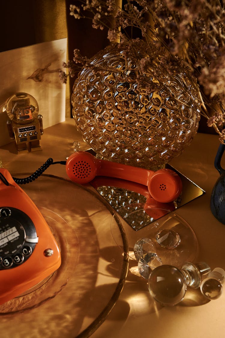 Glass Vase And Phone Handset On Table