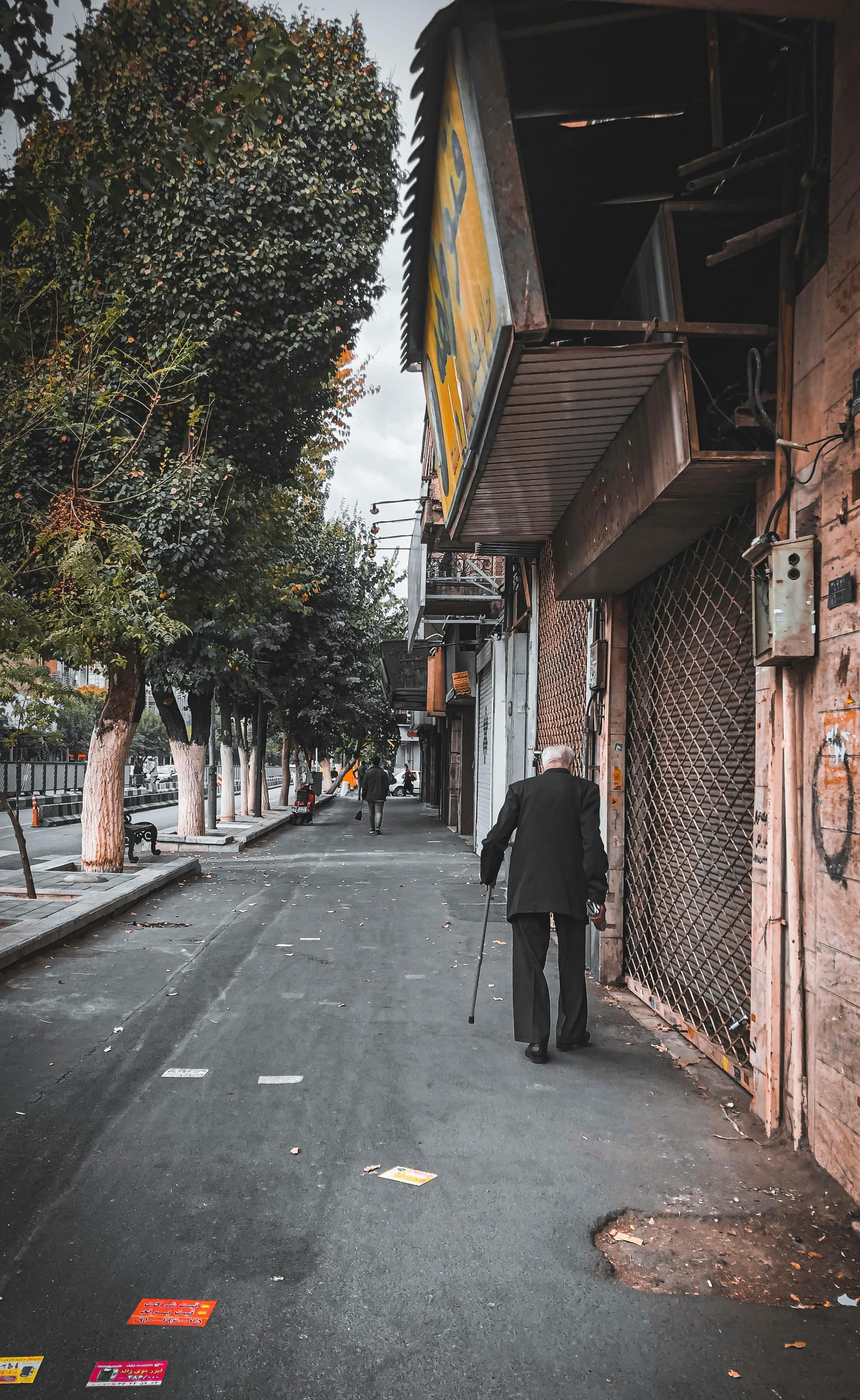 man in black coat walking on sidewalk