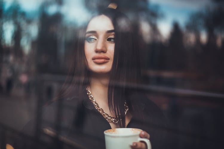 Woman With A Gold Necklace Holding A Cup