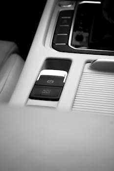 Close-up view of a car's sleek electronic parking brake and control panel.