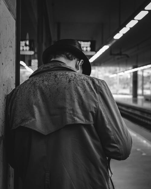 Black and White Photo of Man at Train Station