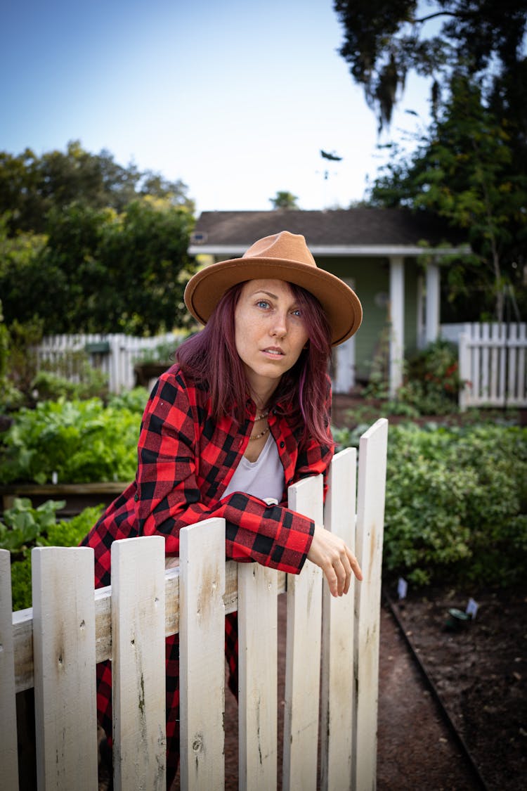 Woman In Red Flannel Leaning On Wooden Fence