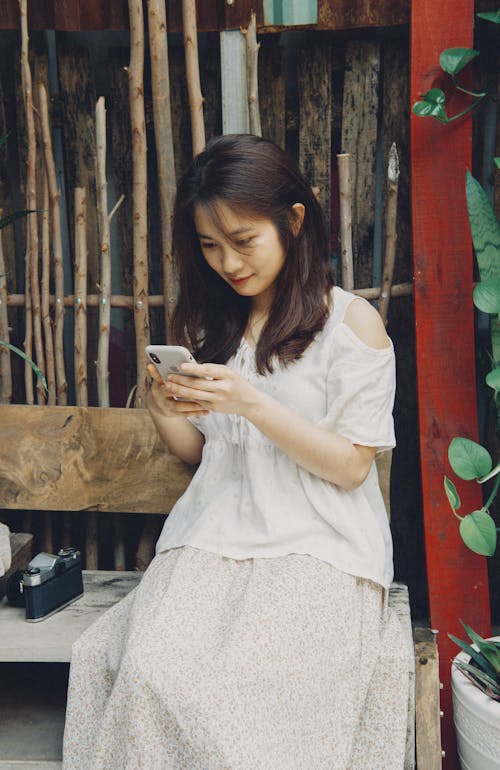 A Woman in White Dress Holding a Cellphone