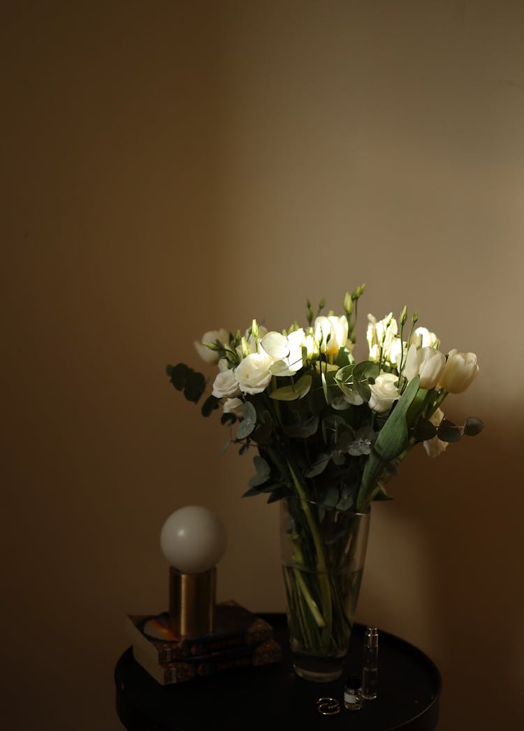 Bunch Of White Roses In Vase Standing On Round Bed Table